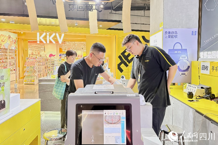 市民在回收點工作人員的幫助下，完成交易。人民網記者 朱虹攝