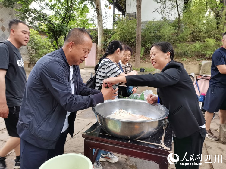 工作人員正在指導游客包粽子。李建生攝