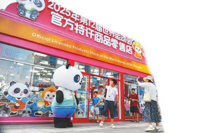 7月14日，游客在世運會官方特許商品零售店紅星路店門口和“蜀寶”打招呼。