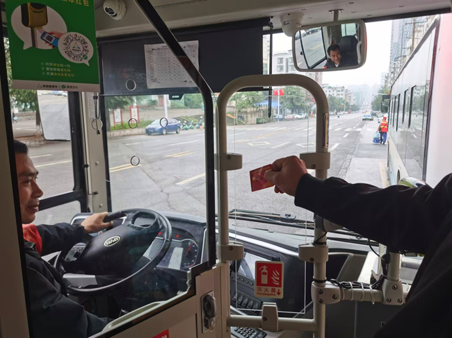 退役軍人向公交車司機展示優待證并免費乘車。華鎣市退役軍人事務局供圖