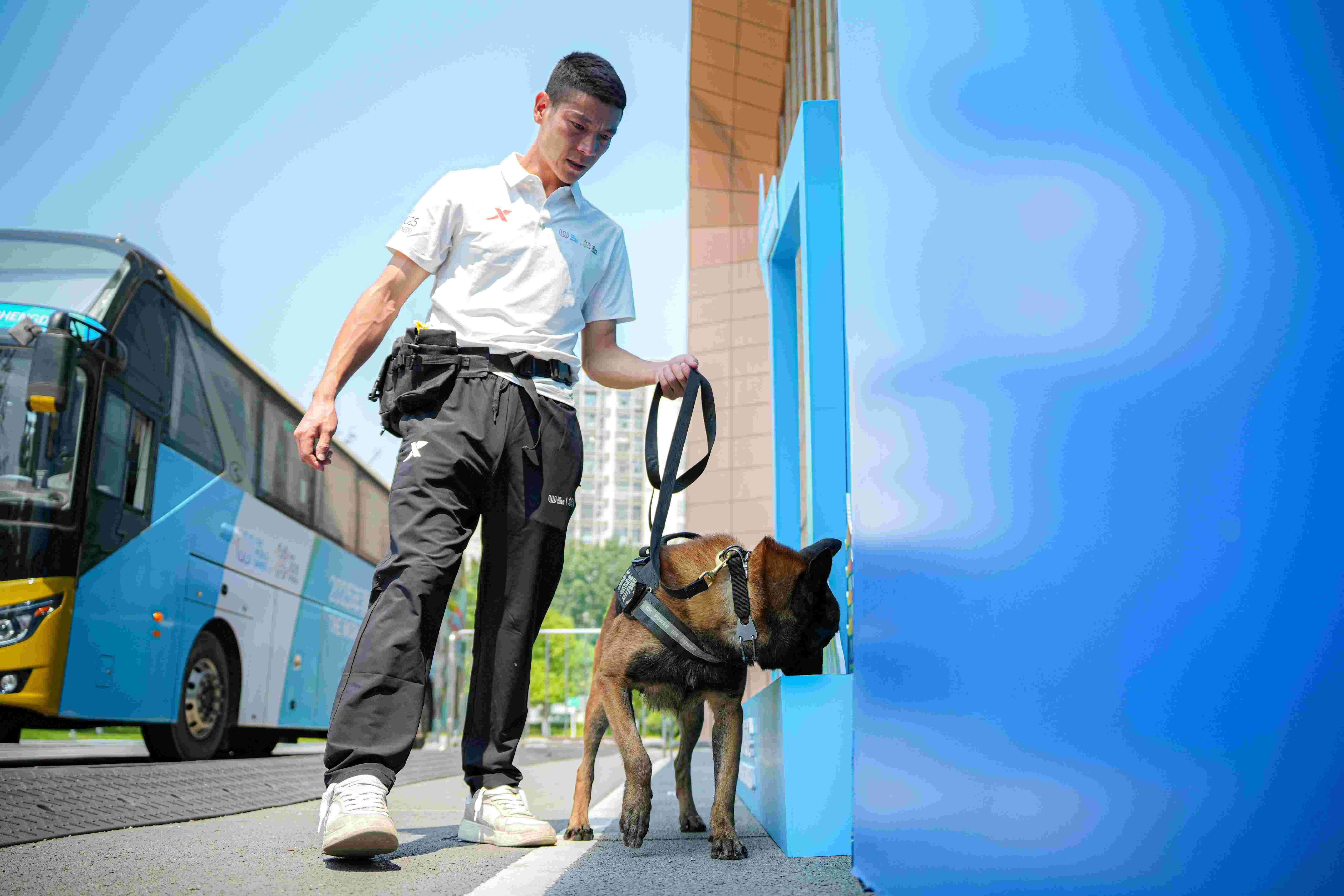 訓犬員韓學軍與搜爆犬黑龍對場館外進行安檢。新都公安供圖