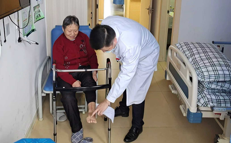 江尚貴了解患者康復情況。陳小芳供圖