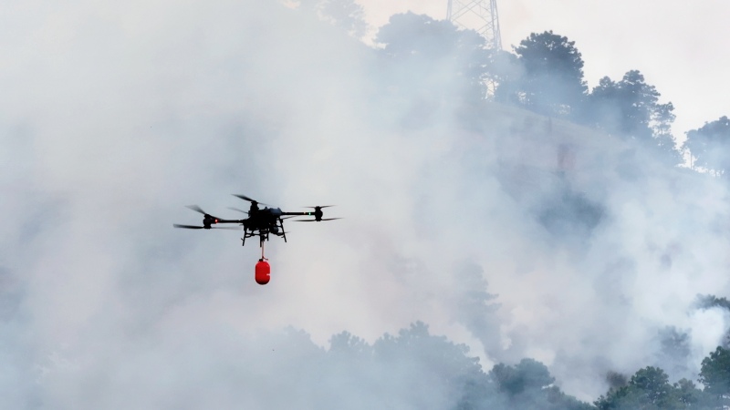 無人機掛載滅火彈進入火場壓制火勢。李威攝